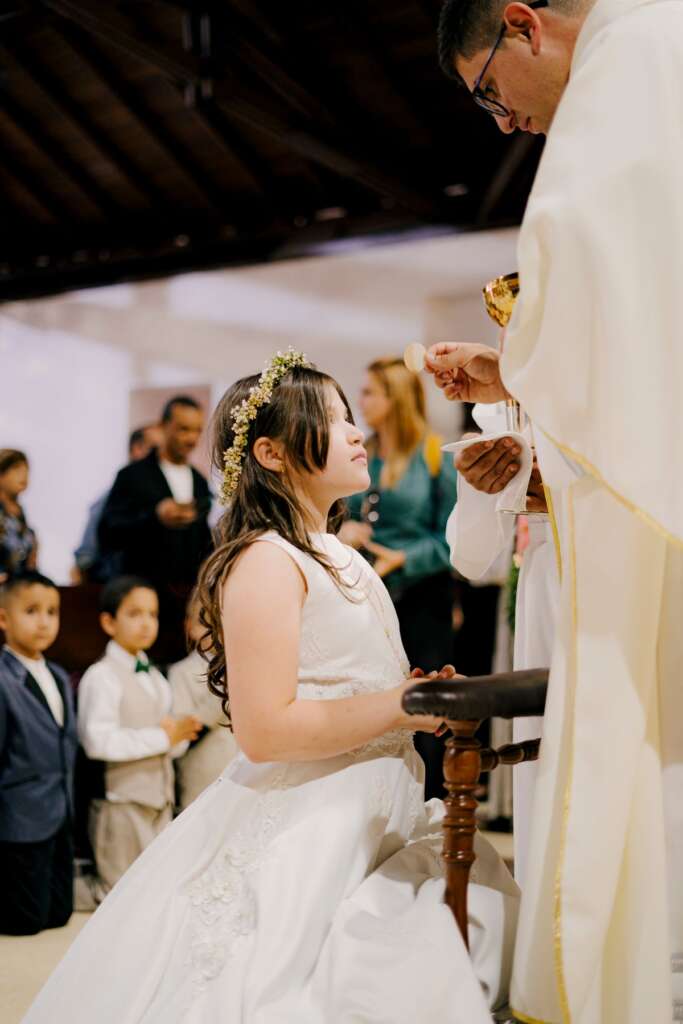 First communion ceremony with family watching