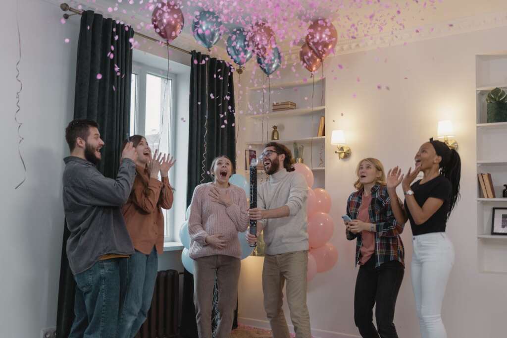 Friends celebrating gender reveal with confetti